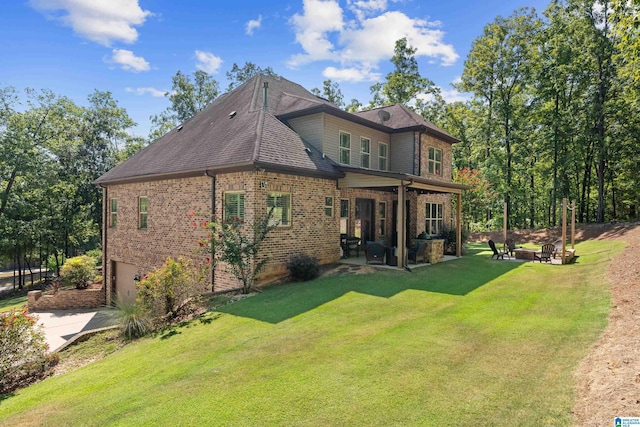 rear view of property featuring a yard and a patio area