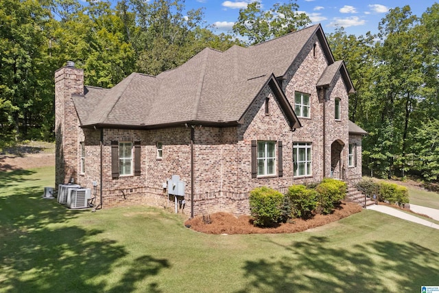 view of side of property featuring a yard and central AC unit