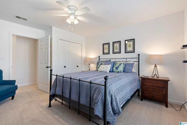 bedroom with light carpet, ceiling fan, and a closet