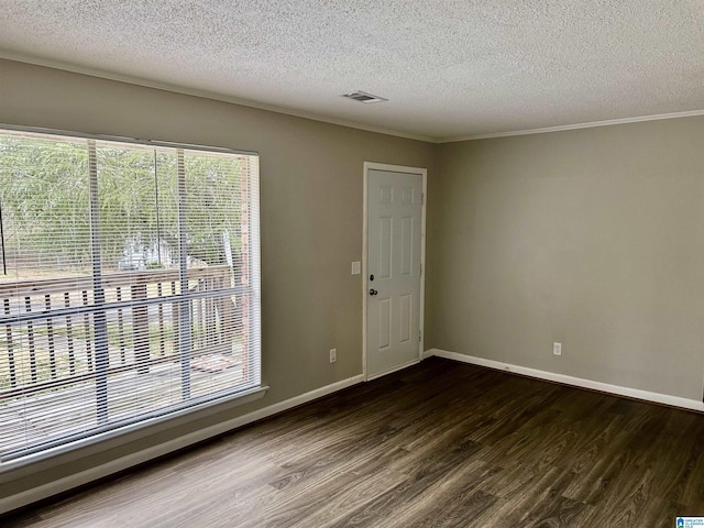 empty room featuring a textured ceiling, dark wood-type flooring, and ornamental molding