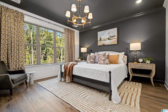 bedroom featuring wood-type flooring, crown molding, and a chandelier