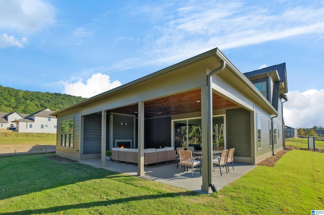 rear view of house with an outdoor living space, a yard, and a patio area