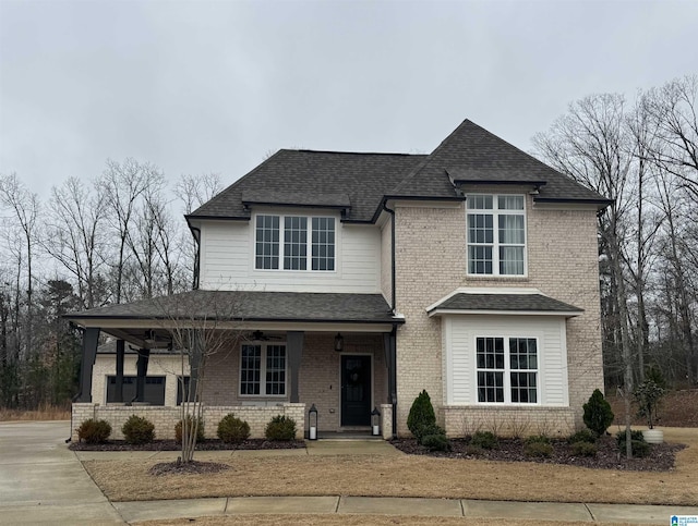 view of front of house with covered porch, brick siding, roof with shingles, and a ceiling fan