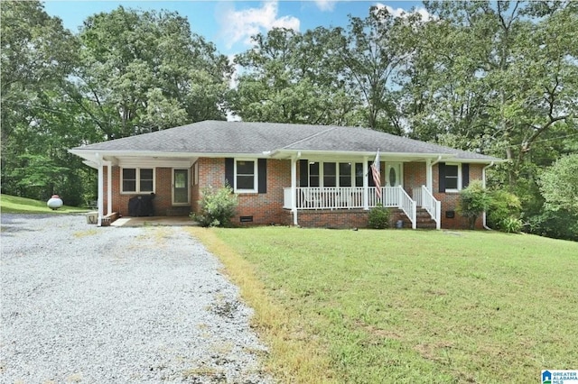 ranch-style home with gravel driveway, brick siding, covered porch, a front yard, and crawl space