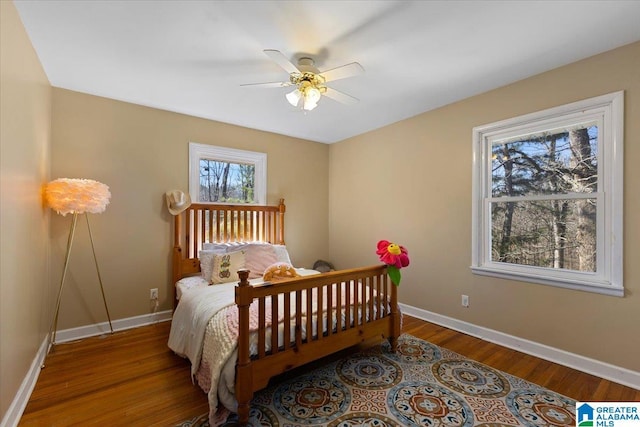 bedroom featuring ceiling fan, baseboards, and wood finished floors