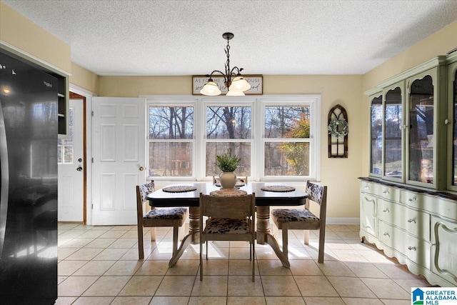 dining room featuring a chandelier, a textured ceiling, baseboards, and light tile patterned floors