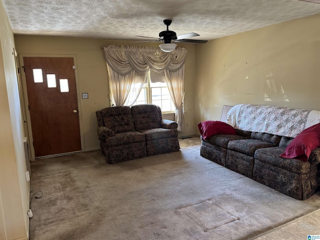 carpeted living room featuring ceiling fan and a textured ceiling