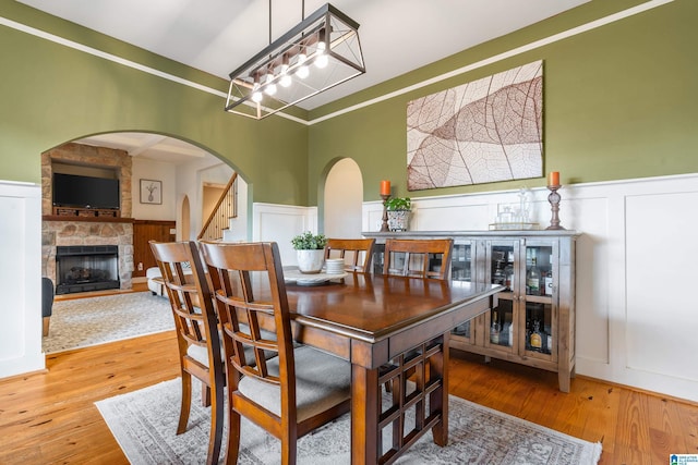 dining room with a fireplace, ornamental molding, and hardwood / wood-style flooring