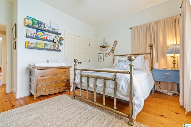 bedroom with light hardwood / wood-style floors and a closet