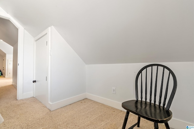 sitting room featuring carpet and lofted ceiling