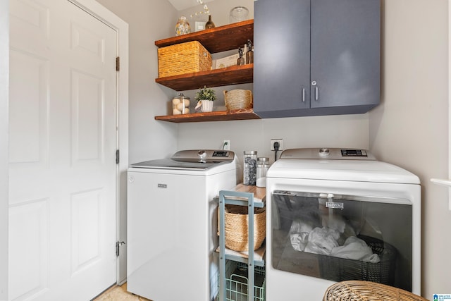 laundry room with washer and dryer and cabinets