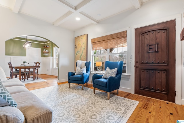 living room featuring light wood-type flooring, beamed ceiling, and coffered ceiling