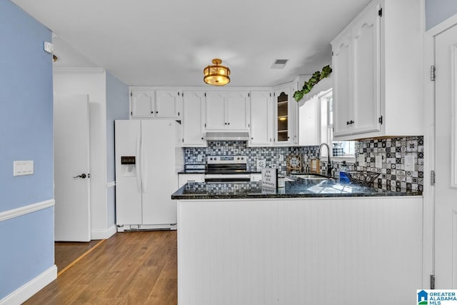 kitchen with white refrigerator with ice dispenser, stainless steel range with electric stovetop, backsplash, white cabinetry, and kitchen peninsula