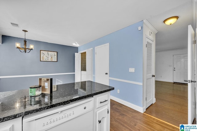 kitchen featuring white cabinetry, decorative light fixtures, dishwasher, dark wood-type flooring, and dark stone countertops