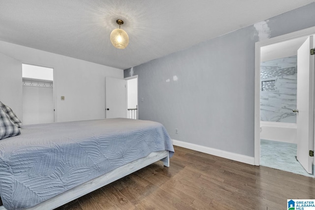 bedroom featuring hardwood / wood-style flooring and connected bathroom