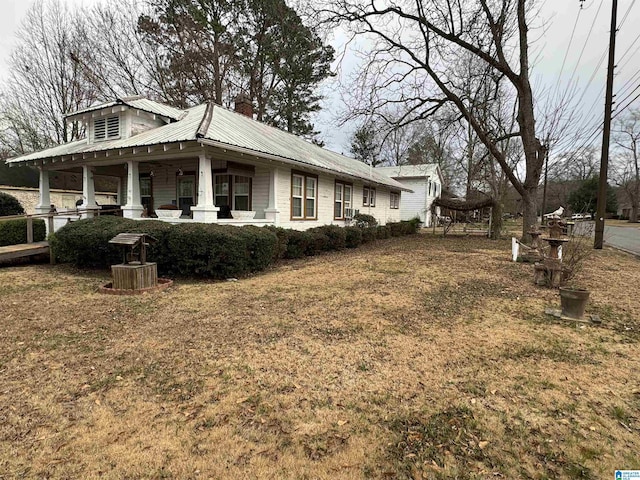 view of property exterior with metal roof and a lawn