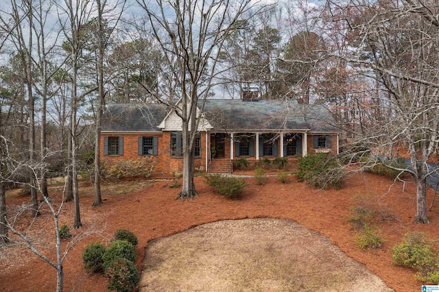 ranch-style home featuring covered porch and brick siding