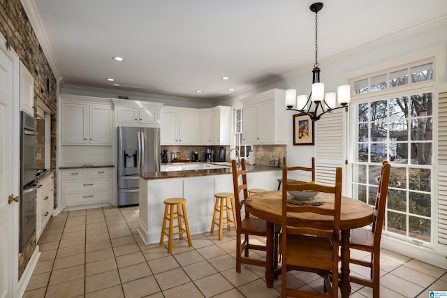 dining space with light tile patterned floors, ornamental molding, a wealth of natural light, and recessed lighting