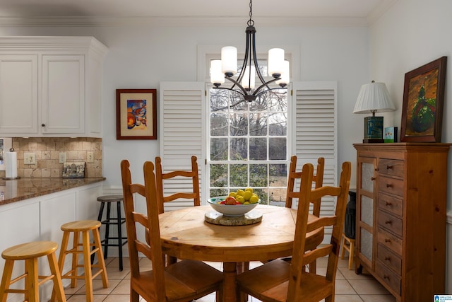 dining area with a notable chandelier, crown molding, and light tile patterned floors