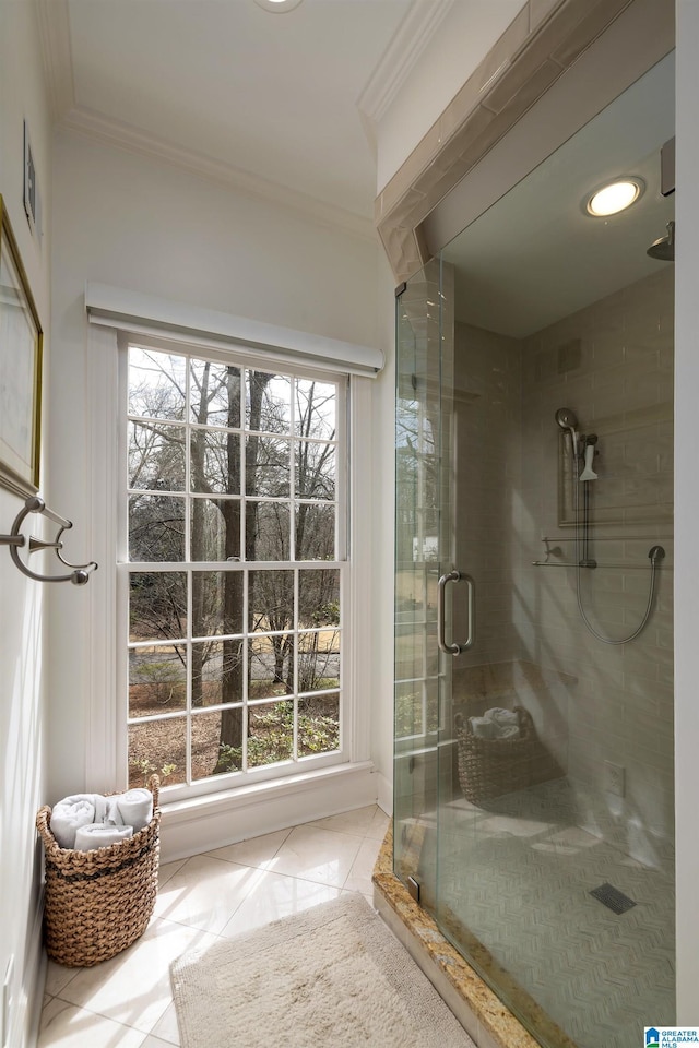 full bathroom with crown molding, a shower stall, and tile patterned floors