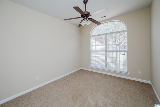 spare room with ceiling fan, carpet floors, and a wealth of natural light