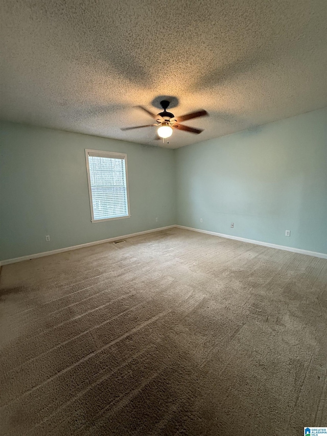 spare room with ceiling fan, carpet floors, a textured ceiling, and baseboards