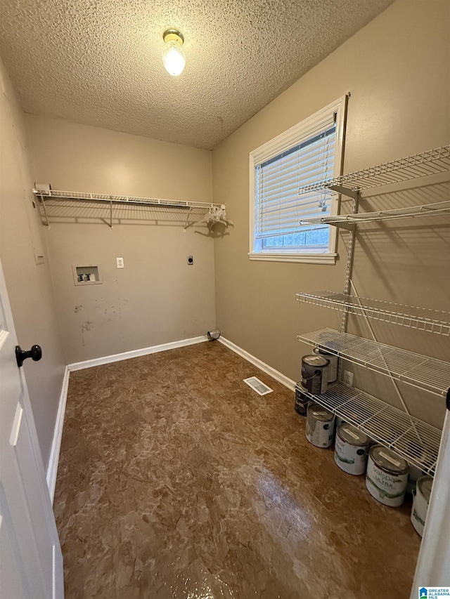 clothes washing area featuring hookup for a washing machine, visible vents, electric dryer hookup, a textured ceiling, and laundry area