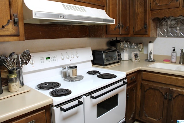 kitchen with range hood, electric stove, a toaster, light countertops, and a sink