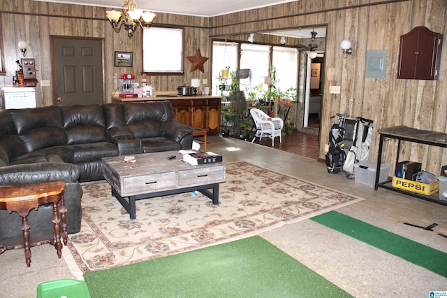 living room featuring electric panel, wood walls, and an inviting chandelier