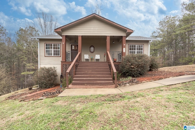 bungalow with a front lawn and covered porch