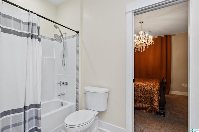 bathroom featuring shower / bath combo, an inviting chandelier, and toilet