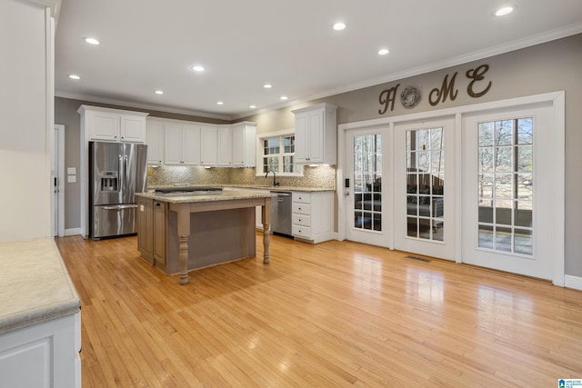 kitchen featuring a breakfast bar area, a center island, a sink, stainless steel appliances, and backsplash