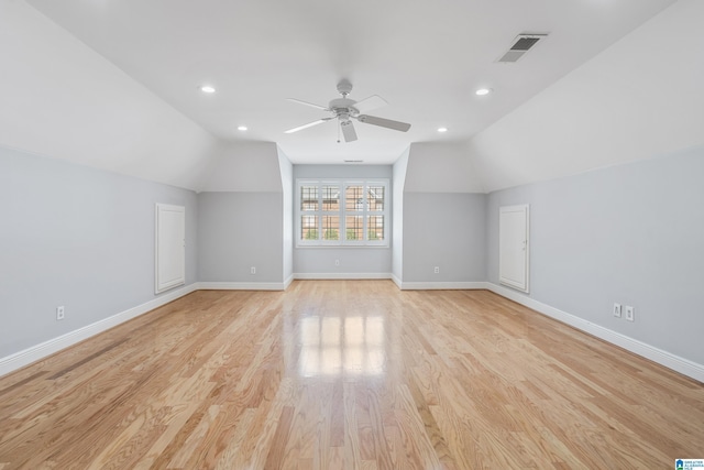 bonus room with light wood-style floors, visible vents, vaulted ceiling, and baseboards