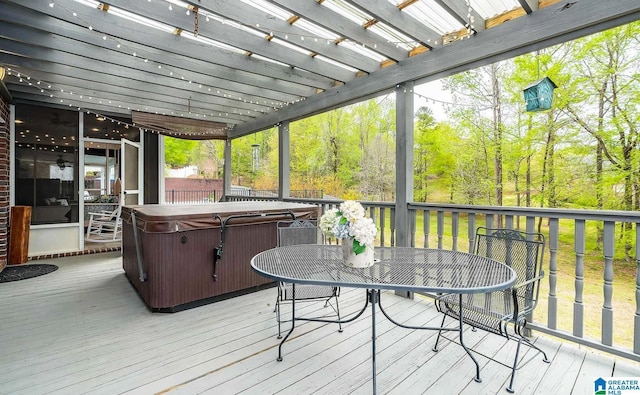 deck with a hot tub, outdoor dining area, and a pergola