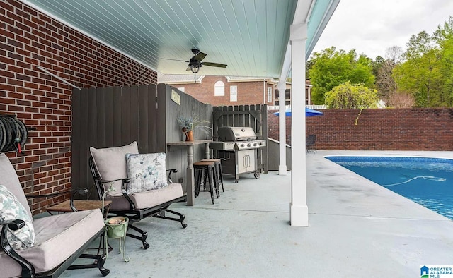 view of patio with area for grilling, a fenced backyard, a fenced in pool, and a ceiling fan