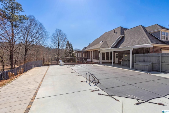 view of pool with a sunroom, a patio area, and a fenced backyard