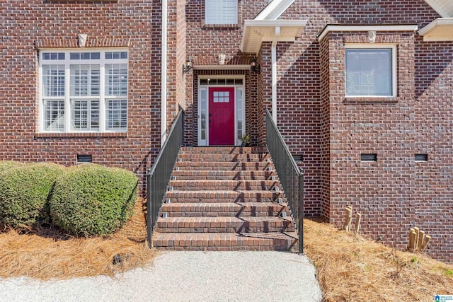 property entrance featuring crawl space and brick siding