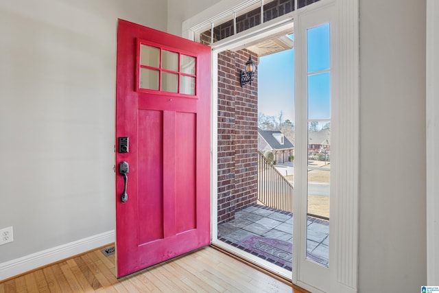 foyer with wood-type flooring, visible vents, and baseboards