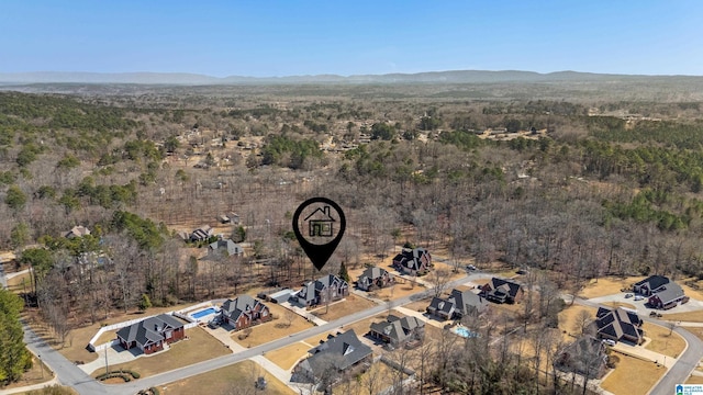 birds eye view of property featuring a wooded view and a mountain view