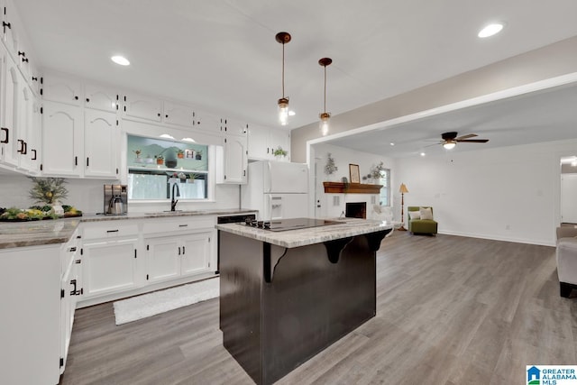 kitchen featuring sink, white cabinetry, decorative light fixtures, a center island, and white fridge