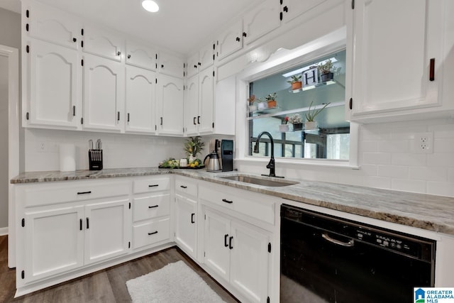 kitchen with black dishwasher, sink, white cabinets, and light stone counters