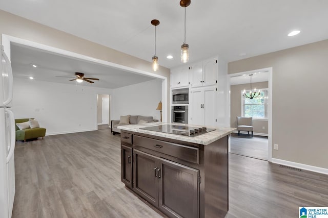 kitchen featuring light hardwood / wood-style flooring, hanging light fixtures, dark brown cabinets, and appliances with stainless steel finishes