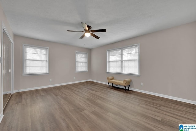 spare room featuring ceiling fan, plenty of natural light, a textured ceiling, and light wood-type flooring