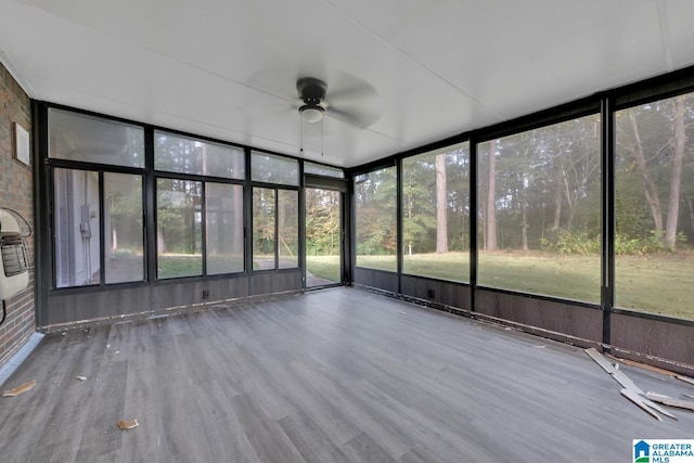 unfurnished sunroom featuring ceiling fan