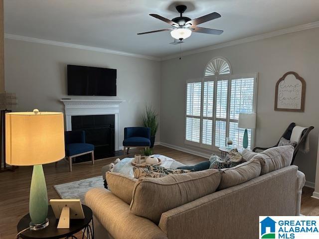 living room featuring crown molding, dark wood-type flooring, and ceiling fan