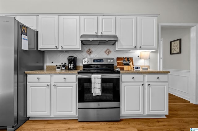 kitchen with light wood-type flooring, appliances with stainless steel finishes, and white cabinets