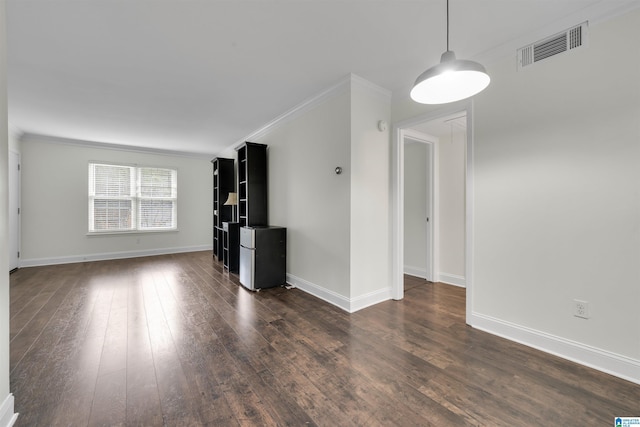 unfurnished living room featuring dark hardwood / wood-style floors and ornamental molding