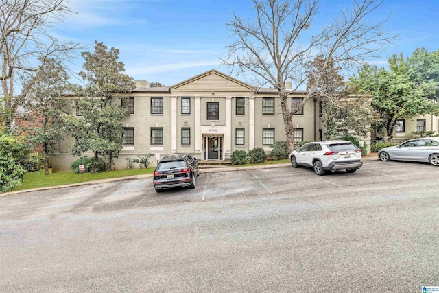 view of front of house featuring uncovered parking and a chimney