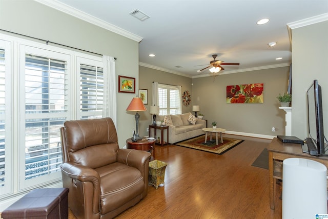 living room with crown molding, wood-type flooring, and ceiling fan