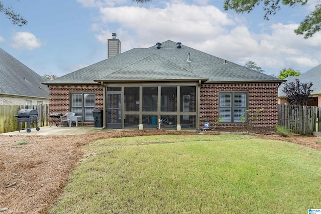 rear view of house featuring a patio area, a sunroom, and a lawn